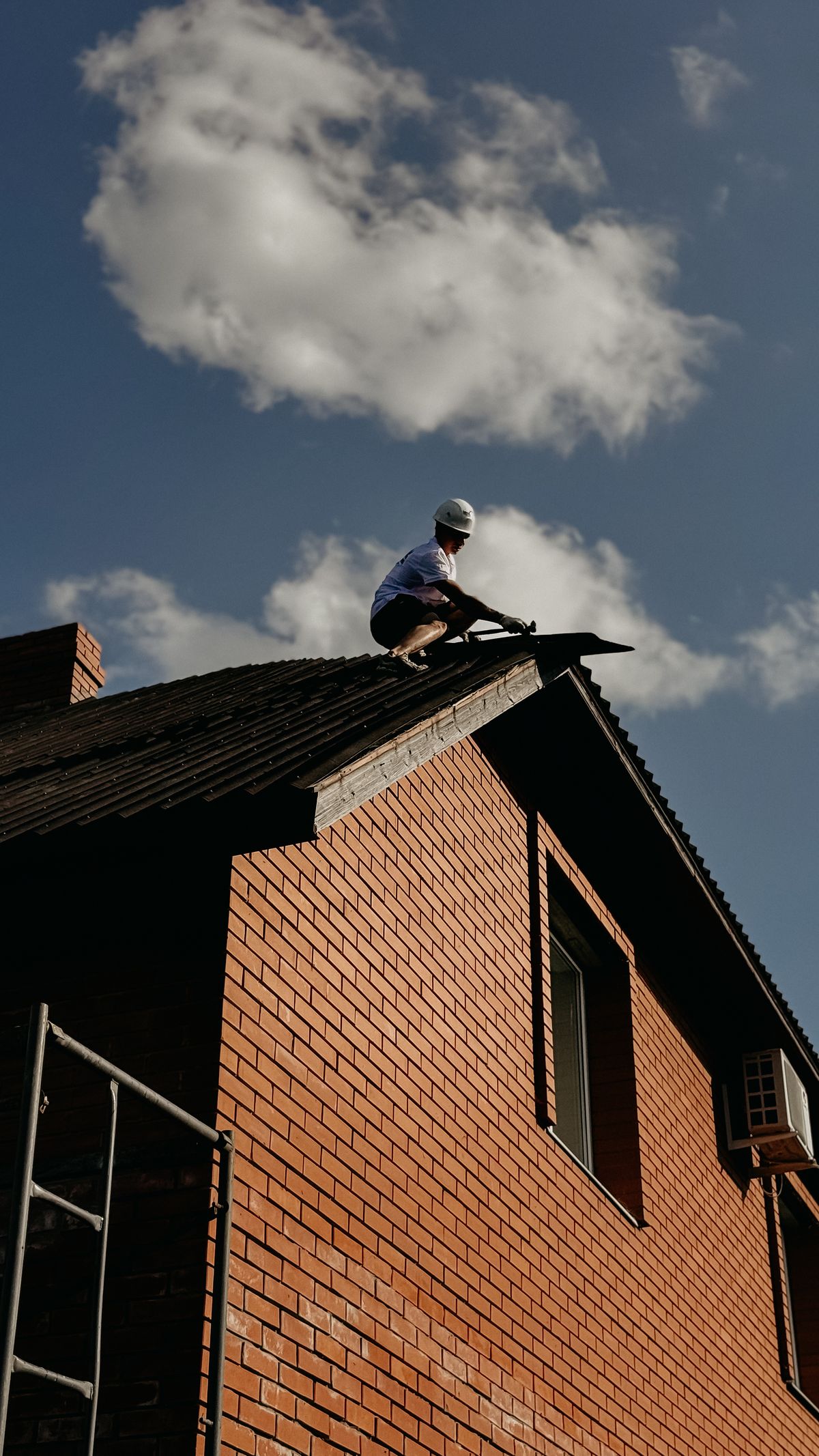 A Roof Pack roofer working on a Tampa Bay rooftop against a blue sky